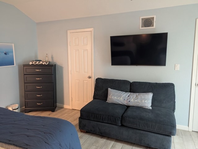 bedroom with vaulted ceiling and light hardwood / wood-style flooring