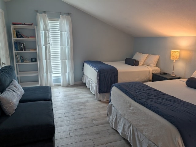 bedroom featuring light hardwood / wood-style flooring and vaulted ceiling