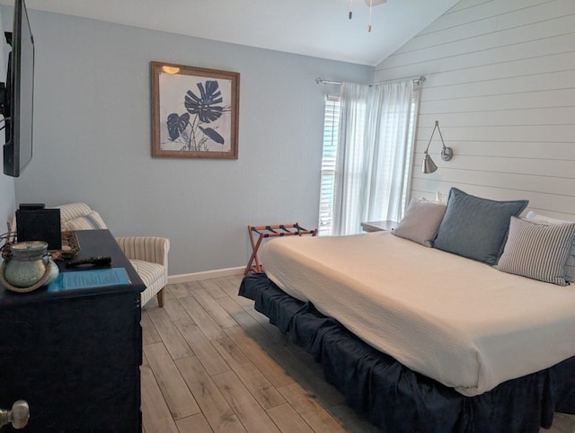 bedroom with lofted ceiling and light wood-type flooring