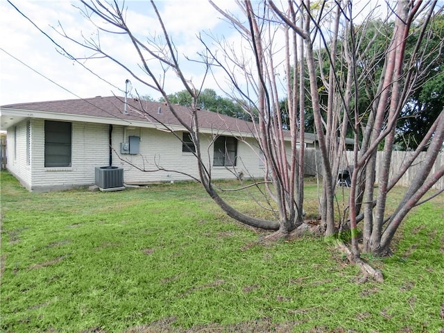 back of property featuring a lawn and cooling unit