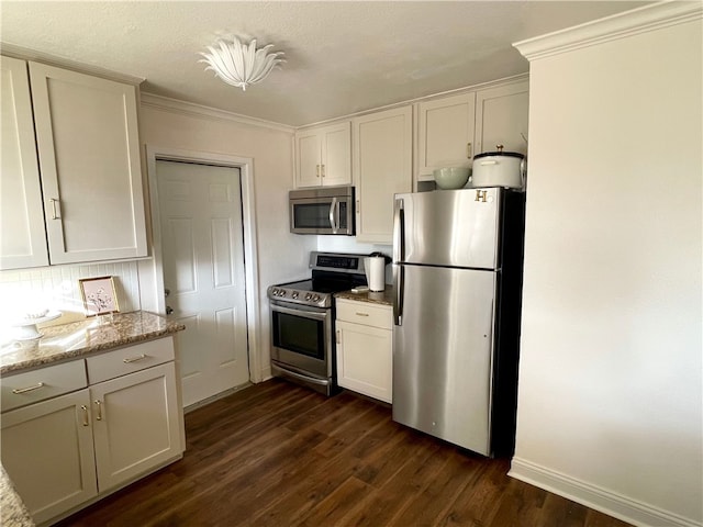 kitchen featuring light stone countertops, appliances with stainless steel finishes, dark hardwood / wood-style flooring, crown molding, and white cabinetry