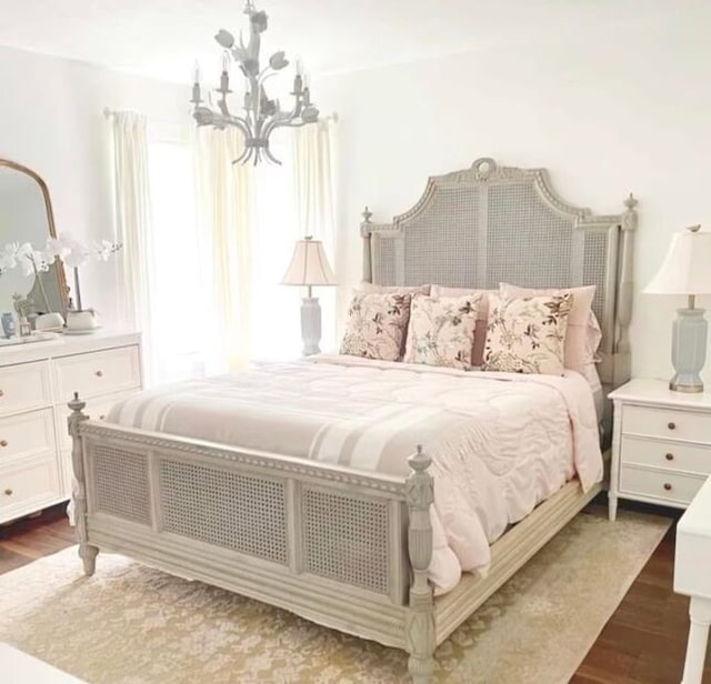 bedroom featuring dark wood-type flooring and a notable chandelier