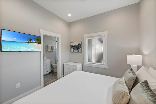 bedroom featuring wood finished floors, multiple windows, connected bathroom, and recessed lighting