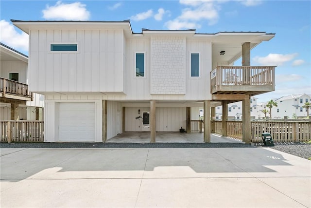view of front of house featuring concrete driveway, a carport, fence, and an attached garage