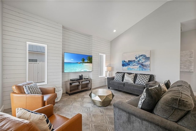 living area with wood walls, recessed lighting, and high vaulted ceiling