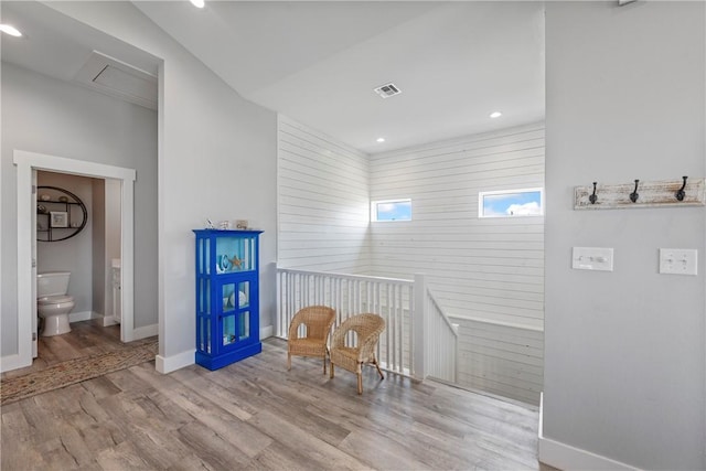 sitting room with baseboards, wood finished floors, and recessed lighting