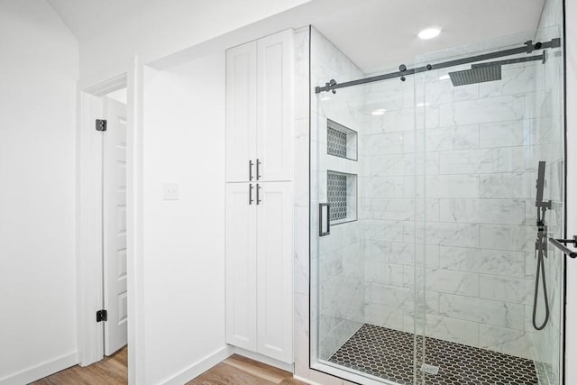 full bath with wood finished floors, a shower stall, baseboards, and recessed lighting