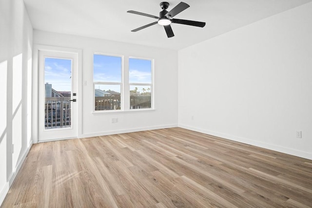 spare room featuring wood finished floors, baseboards, and a ceiling fan