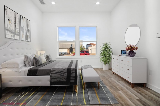 bedroom featuring wood finished floors, recessed lighting, and baseboards
