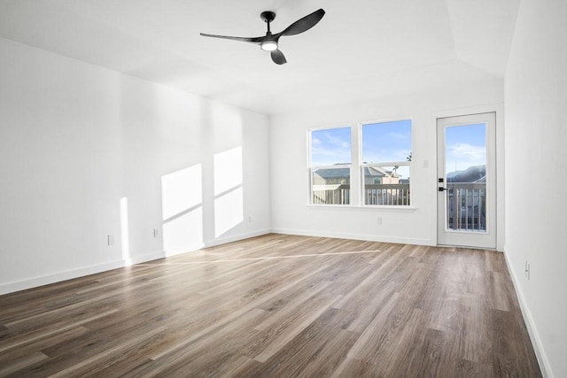 unfurnished room featuring a ceiling fan, wood finished floors, baseboards, and vaulted ceiling