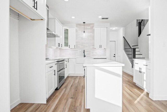 living area featuring light wood-style floors, visible vents, and ceiling fan with notable chandelier