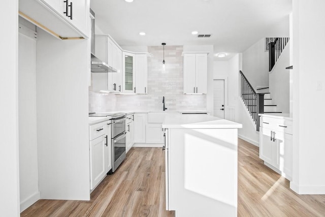 kitchen with range with two ovens, a sink, a kitchen island, decorative backsplash, and recessed lighting
