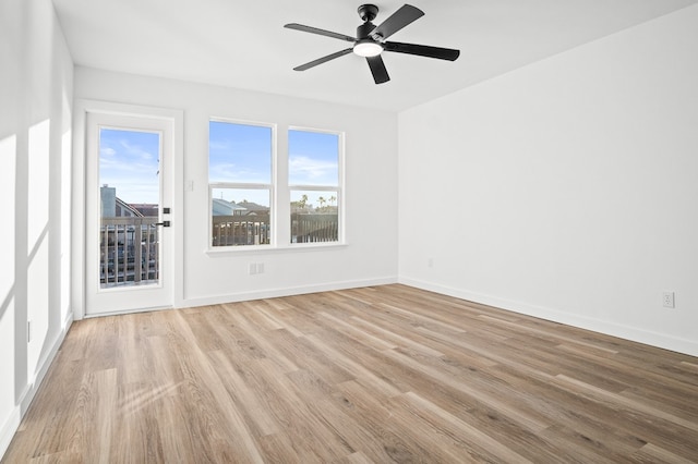 empty room featuring light wood-style floors, ceiling fan, and baseboards