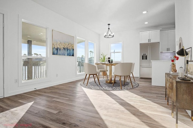 dining room with a chandelier, wood finished floors, recessed lighting, and baseboards