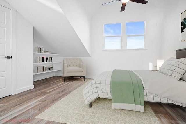 bedroom featuring lofted ceiling, wood finished floors, a ceiling fan, and baseboards