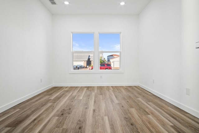 empty room with recessed lighting, light wood-type flooring, and baseboards