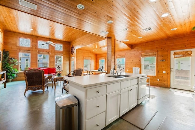 kitchen featuring a sink, open floor plan, dishwasher, and finished concrete flooring