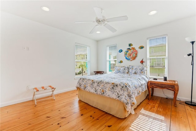 bedroom with light wood finished floors, multiple windows, and baseboards