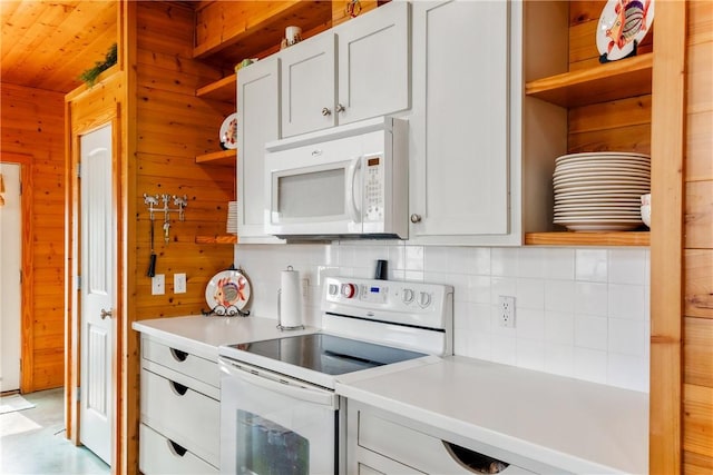 kitchen with open shelves, white appliances, wood walls, light countertops, and decorative backsplash