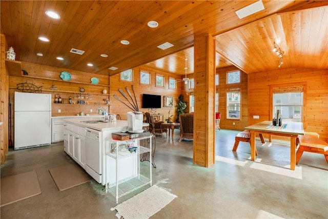 kitchen featuring white appliances, wooden walls, finished concrete flooring, open shelves, and lofted ceiling