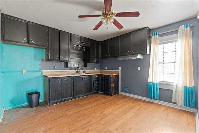 3425 Harold Dr, Corpus Christi, TX 78415 - kitchen featuring light wood-type flooring, ceiling fan, dark cabinets, and light countertops