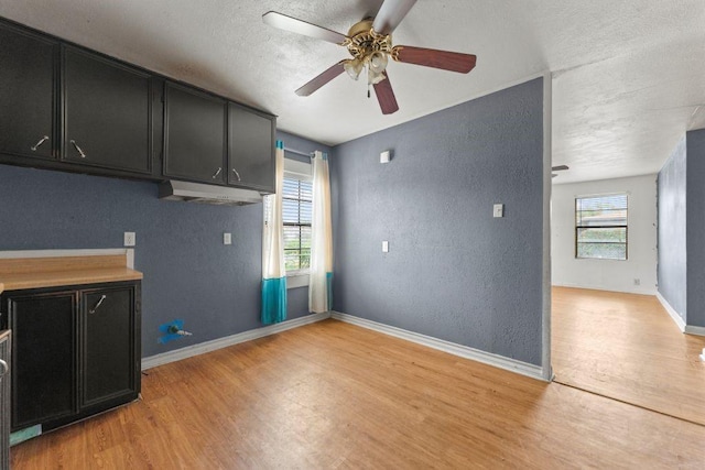 3425 Harold Dr, Corpus Christi, TX 78415 - laundry area with light wood-style floors, a textured wall, a ceiling fan, and a textured ceiling