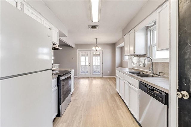 6701 Meadowbreeze Pkwy, Corpus Christi, TX 78414 - kitchen with stainless steel appliances, a sink, white cabinetry, and light countertops