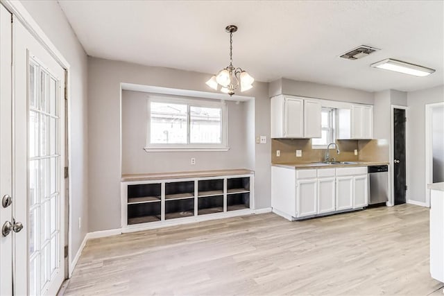 6701 Meadowbreeze Pkwy, Corpus Christi, TX 78414 - kitchen with stainless steel dishwasher, white cabinets, a chandelier, a sink, and light wood-type flooring