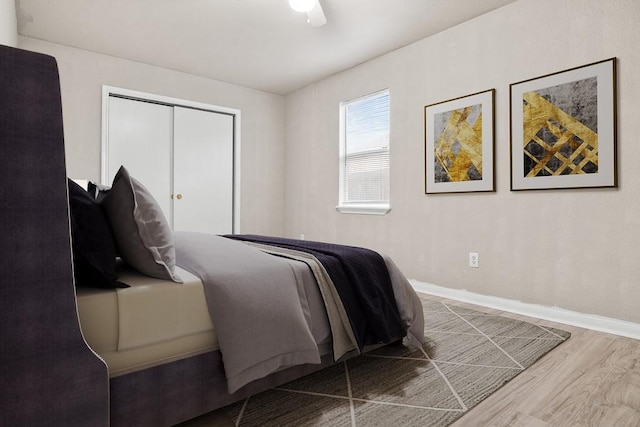 bedroom with ceiling fan, hardwood / wood-style flooring, and a closet