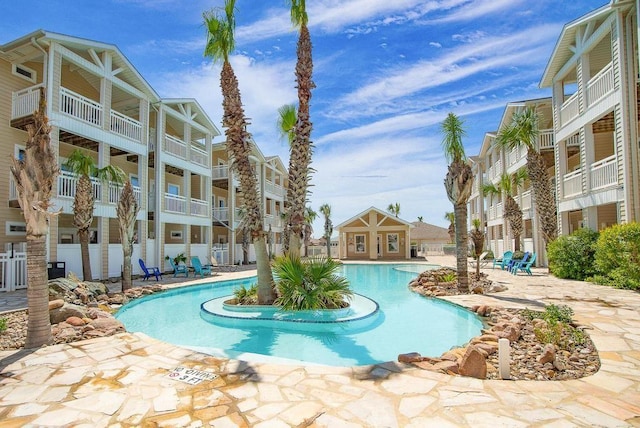 pool with a patio area and fence