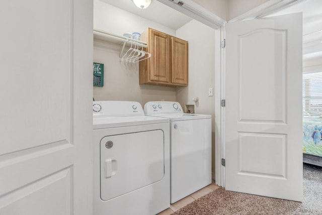 washroom featuring cabinet space, independent washer and dryer, and light tile patterned flooring