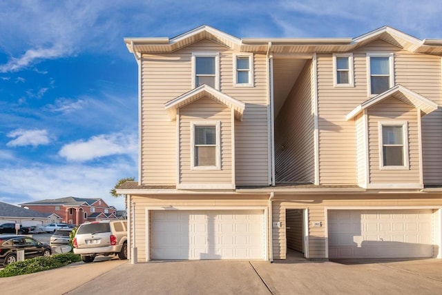 view of property with a garage and driveway