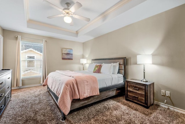 carpeted bedroom featuring baseboards, a tray ceiling, a ceiling fan, and ornamental molding