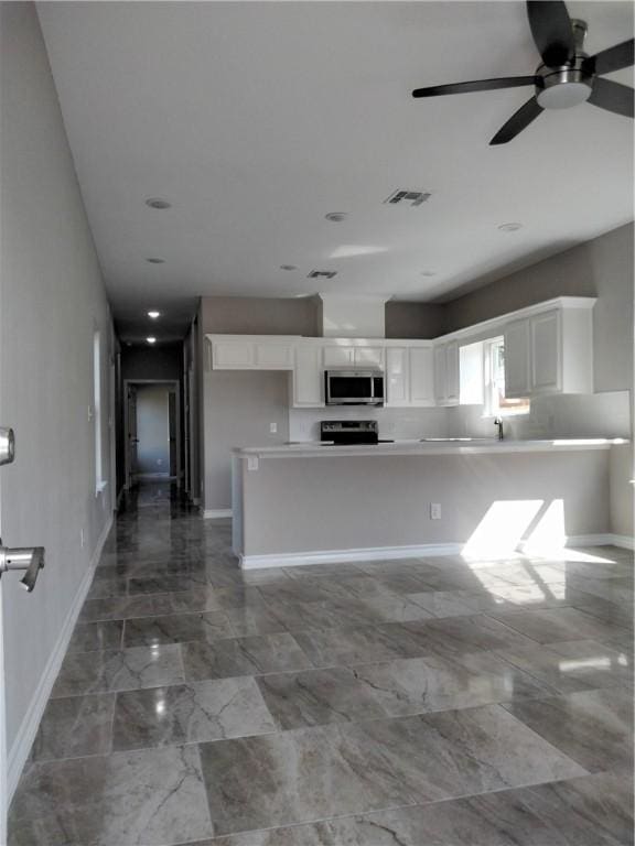 3018 Greenwood Dr, Corpus Christi, TX 78405 - kitchen featuring a ceiling fan, white cabinetry, stainless steel microwave, marble finish floor, and visible vents