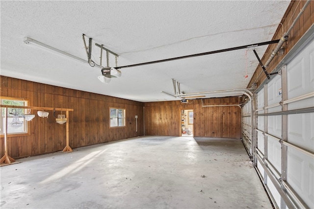 garage featuring a garage door opener and wooden walls