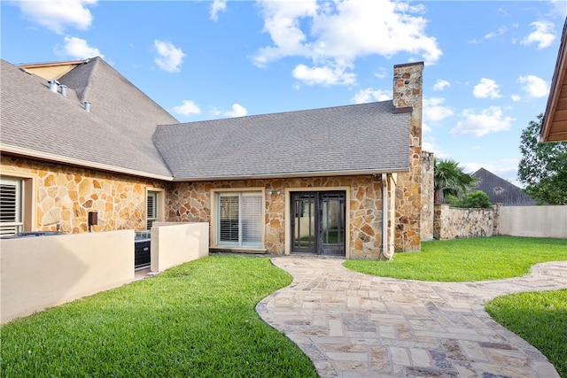 rear view of property featuring a patio and a yard