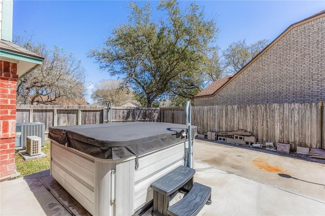 deck featuring cooling unit, a fenced backyard, a patio, and a hot tub