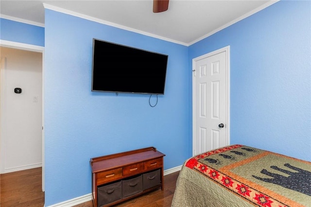 bedroom with baseboards, dark wood finished floors, a ceiling fan, and crown molding