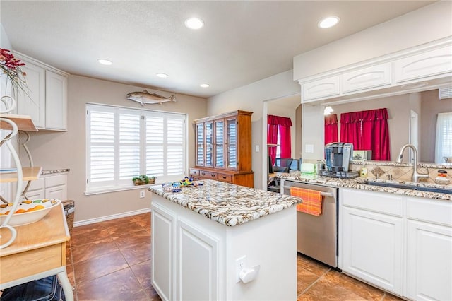 kitchen featuring recessed lighting, white cabinets, a sink, and stainless steel dishwasher