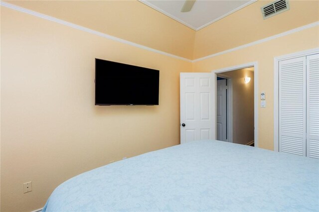 bedroom with a ceiling fan, a closet, visible vents, and crown molding