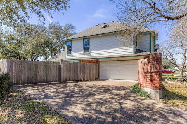 view of side of property with brick siding, fence, driveway, and an attached garage