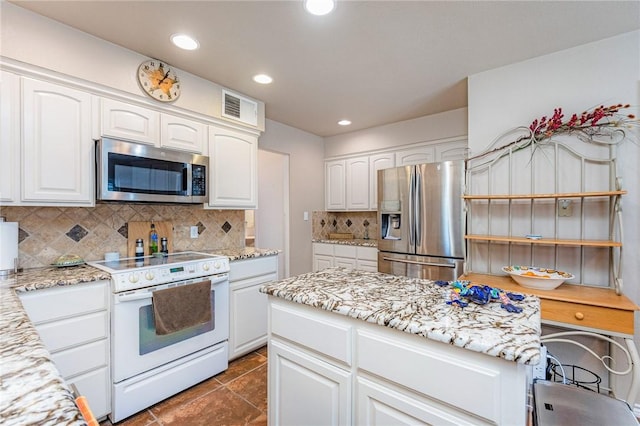 kitchen featuring stainless steel appliances, white cabinetry, and light stone counters