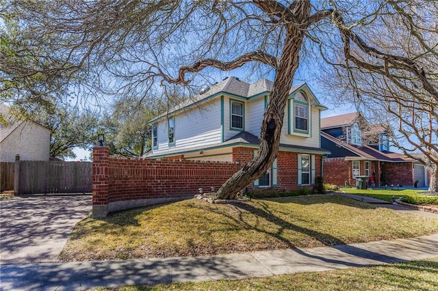 view of front of house with fence, a front lawn, and brick siding