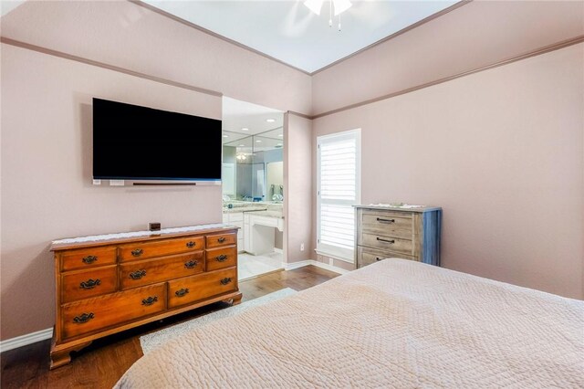 bedroom with ensuite bathroom, ceiling fan, baseboards, and wood finished floors