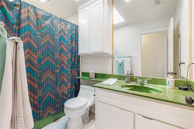 full bathroom featuring a shower with curtain, visible vents, vanity, and toilet