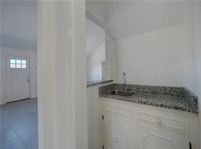 4802 Eider Dr, Corpus Christi, TX 78413 - kitchen featuring white cabinets, lofted ceiling, light stone counters, and tile patterned flooring