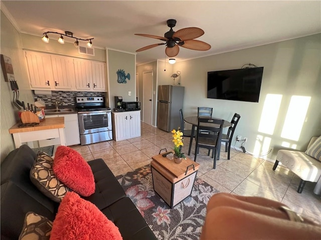 living room with ceiling fan, crown molding, sink, and light tile patterned flooring