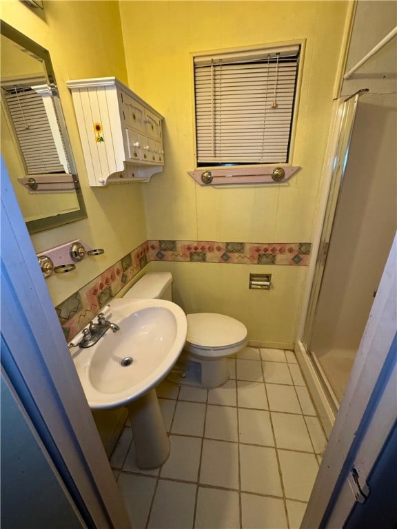 bathroom featuring walk in shower, sink, toilet, and tile patterned flooring