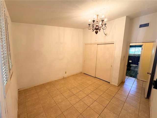 interior space with light tile patterned floors and a chandelier