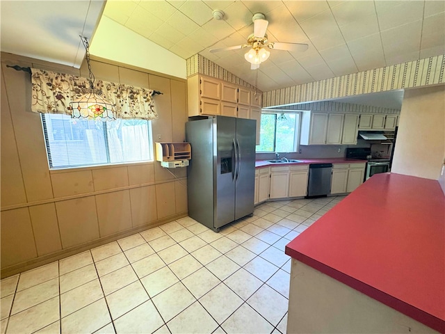 kitchen featuring sink, ceiling fan, appliances with stainless steel finishes, light tile patterned flooring, and vaulted ceiling